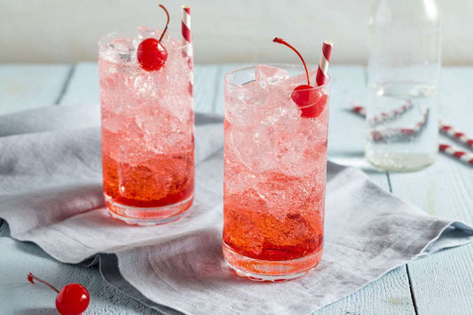 Bottle of grenadine with red content on white background